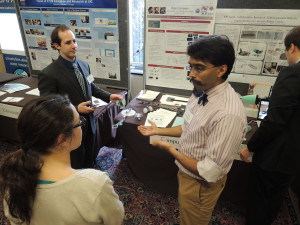 Ankur Mehta, center, of MIT, explains his printable robots to an attendee at the 2014 CNSF Exhibition.